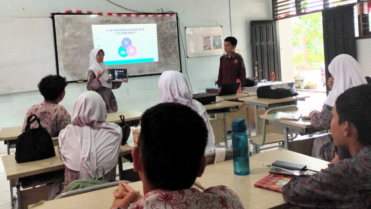 Hanif saat menemani siswa latihan presentasi. Foto: UKM DSC
